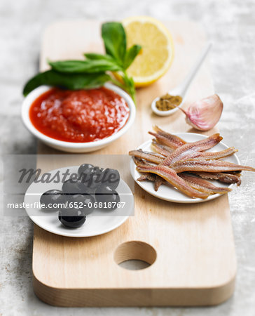 Ingredients for toasts with anchovies and light tomato tapenade