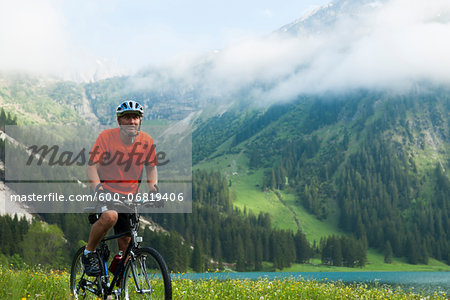 Mature Man Riding Mountain Bike by Vilsalpsee, Tannheim Valley, Tyrol, Austria Mature Man Riding Mountain Bike by Vilsalpsee, Tannheim Valley, Tyrol, Austria