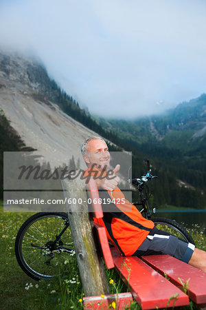 Mature Man on Bench by Lake with Mountain Bike, Vilsalpsee, Tannheim Valley, Tyrol, Austria