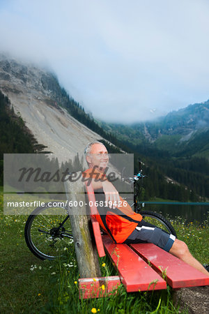 Mature Man on Bench by Lake with Mountain Bike, Vilsalpsee, Tannheim Valley, Tyrol, Austria