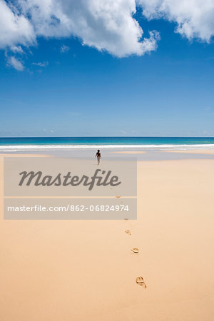 South America, Brazil, Pernambuco, Fernando de Noronha Island, a girl walking along Father's Well beach MR