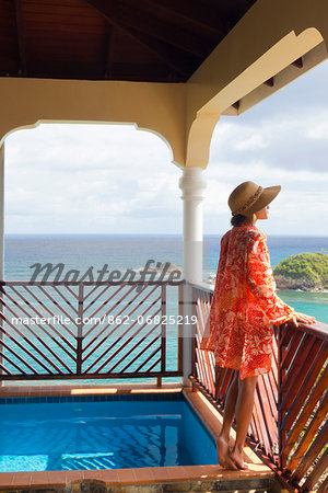Dominica, Calibishie. A young woman admires the view from the Penthouse at Calibishie Cove. (MR).