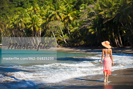 Dominica, Calibishie. A young woman walks along Batibou Beach. (MR).