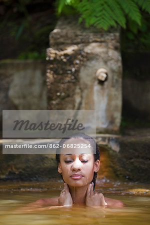 Dominica, Roseau. A young woman relaxes in the natural springs at Papillote Wilderness Retreat. (MR). Dominica, Roseau. A young woman relaxes in the natural springs at Papillote Wilderness Retreat. (MR).
