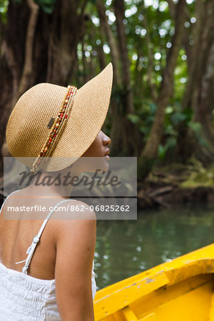 Dominica, Portsmouth. A young woman sits on a boat on the Indian River, one of Dominica's most popular tourist attractions. (MR).