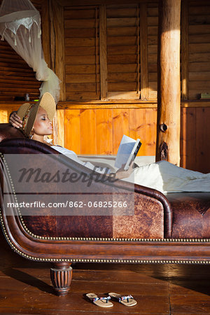 Dominica, Portsmouth, Tanetane. A young lady reads whilst laying on a Chaise Lounge at Manicou River Resort.(MR). Dominica, Portsmouth, Tanetane. A young lady reads whilst laying on a Chaise Lounge at Manicou River Resort.(MR).