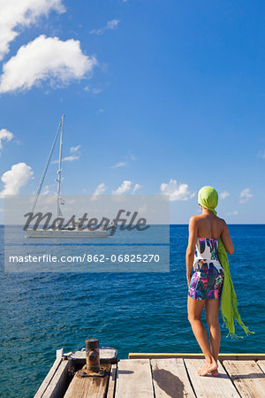 Dominica, Roseau. A young woman looks out to sea near Roseau. (MR).