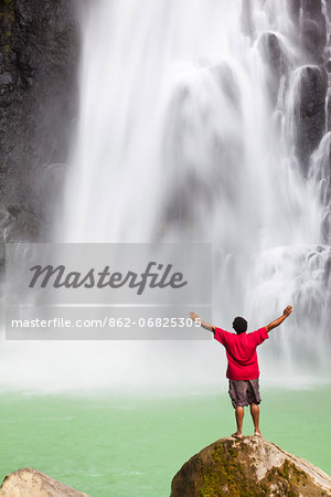 Dominica, Delices. A man stands at the base of Victoria Falls, one of the tallest and most spectacular waterfalls on Dominica. (MR).