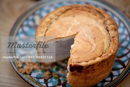 Nottinghamshire, UK. Melton Mowbray pork pie on handmade ceramic plate.