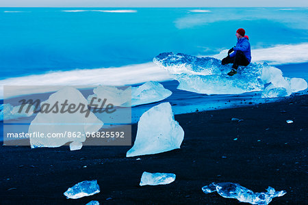 Iceland, eastern region, Jokulsarlon iceberg lagoon, man on icebergs washed up on the beach (MR)