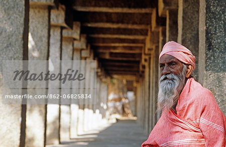 Asia, India, Karnataka, Hampi, Hampi bazaar.  Old pillgrim man seated in the shade of the Sule bazaar.