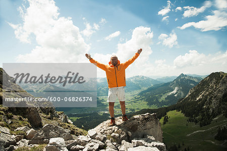 Mature man with arms raised in air, hiking in mountains, Tannheim Valley, Austria