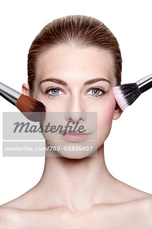 Close-Up of Young Woman Applying Make-Up with Brushes on White Background