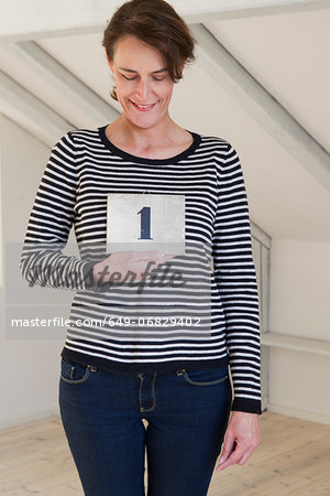 Woman holding piece of paper with number 1