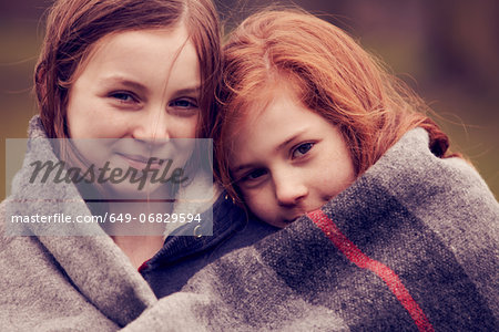 Portrait of girls wrapped in a blanket outdoors