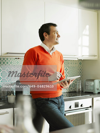 Mature man using tablet in kitchen Mature man using tablet in kitchen