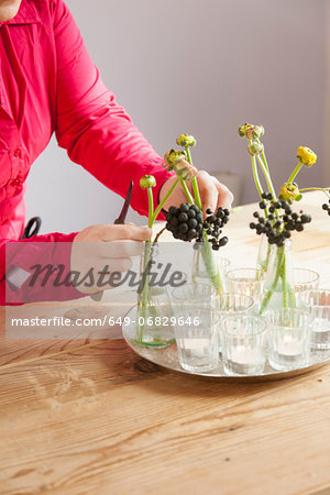 Close up of young woman arranging fresh flowers and plants