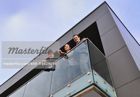 Three office colleagues on balcony, low angle
