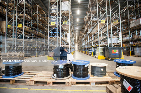 Male warehouse worker checking pallet order