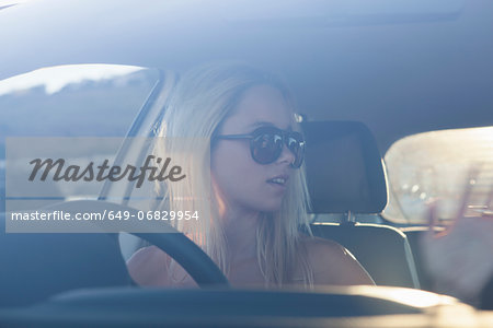 Young blonde women in car wearing sunglasses