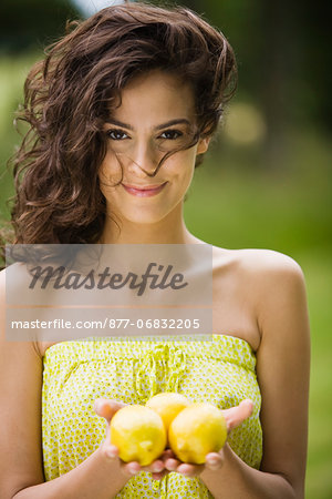 Young woman holding three lemons