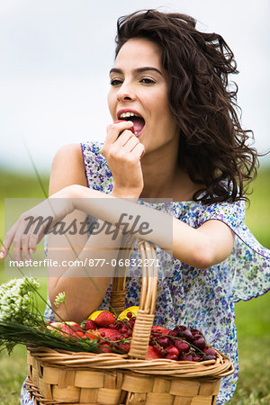 Young woman with a basket full of fruits