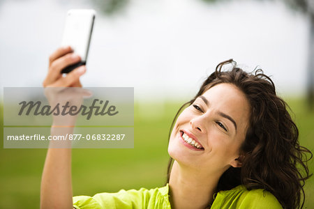 Young woman holding Iphone, oudoors