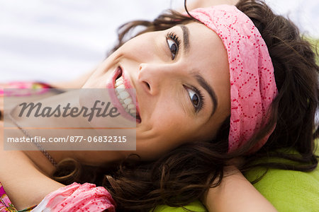 Young woman smiling, lying, oudoors