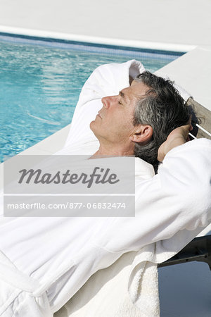 Senior man lying near a pool