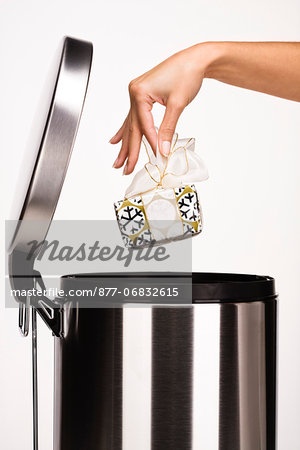 Woman's hand throwing a gift in the garbage