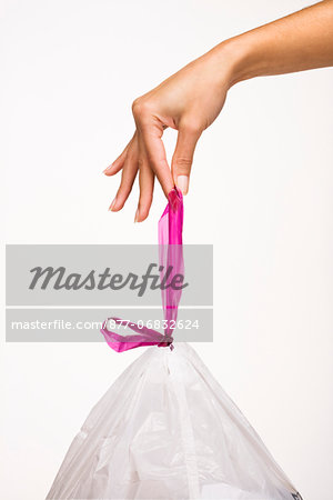 Woman's hand holding a trash bag