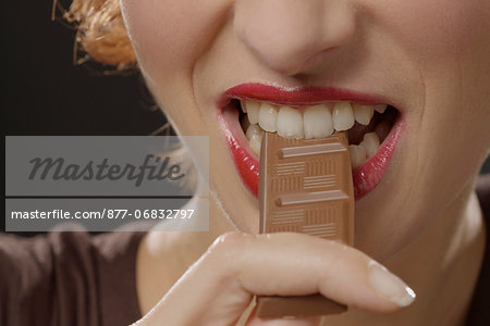 Woman eating chocolate, close-up of mouth