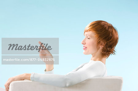 Woman looking at her hand in a clear blue background