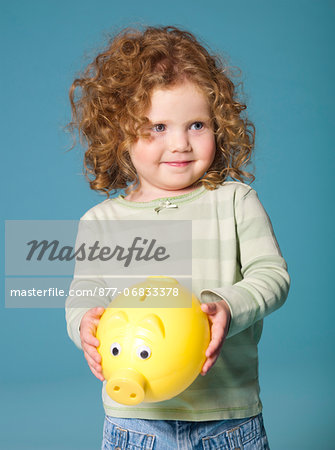 Little girl holding piggy bank