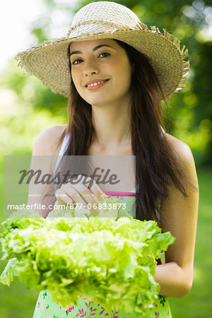 Young woman holding a lettuce