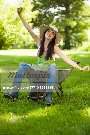 Young woman sitting in wheelbarrow
