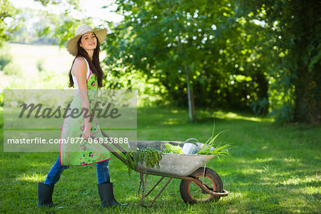 Young woman pushing wheelbarrow