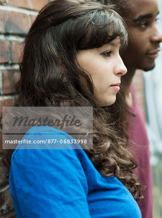 Teenagers leaning against wall