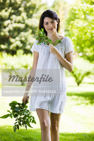 Young woman holding leaves