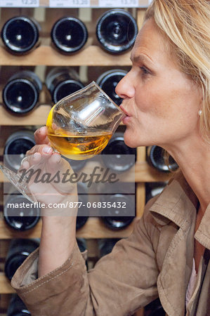 Woman profile, holding a glass of white wine, close up