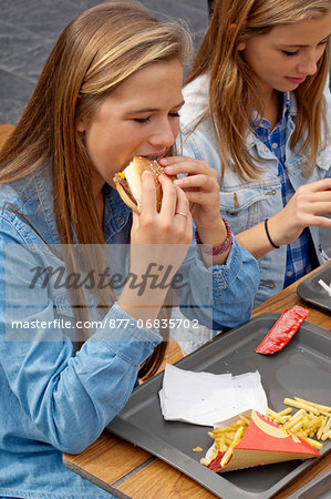 Teenagers eating an hamburger