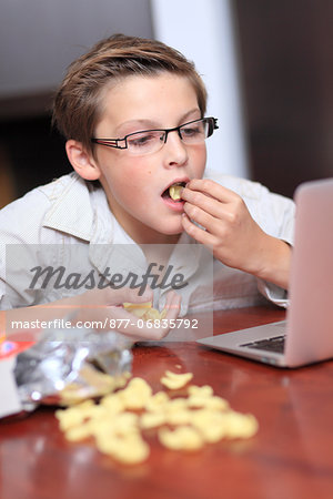 France, young boy with a computer and chips.