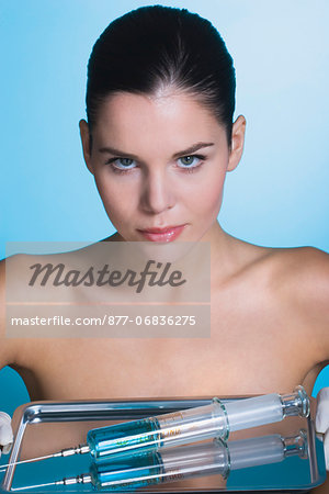 Young woman holding tray with syringe