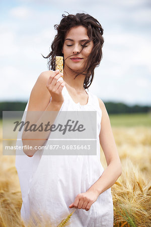 Portrait of young woman holding cereal bar