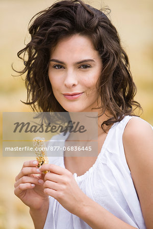Portrait of young woman holding cereal bar