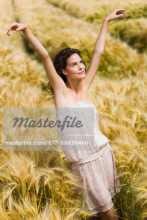 Young woman streching in wheat field