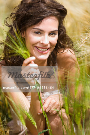Young smiling woman holding wheat