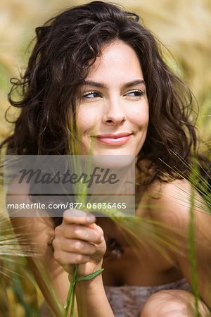 Young smiling woman holding wheat