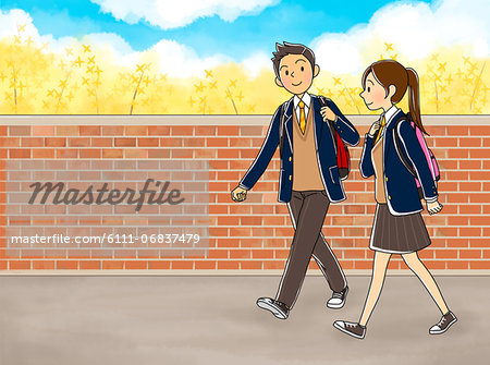 Students walking besides brick wall while going to school