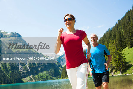 Mature man and woman power walking, Lake Vilsalpsee, Tannheim Valley, Austria